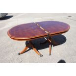 A yew and banded double pedestal dining table with one extra leaf, 39" x 98" when fully extended,