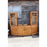 An Ercol light ash wall unit with two glazed cupboards over two canted cupboards and central