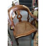 A Victorian mahogany elbow chair with cane panel seat, on turned supports