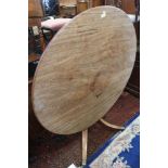 An early 19th century faded mahogany circular tilt top dining table, on vase turned column and