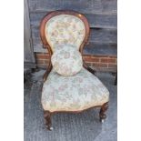 A Victorian carved walnut showframe occasional chair, upholstered in a floral brocade, on cabriole