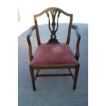 A Sheraton carved mahogany elbow chair with pierced splat and drop-in seat, on square taper