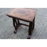 A nest of three rectangular quarter veneered yew wood occasional tables, on lyre end supports,