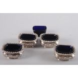 Four matching silver salts with embossed decoration and five blue glass liners, 6.3oz troy approx (