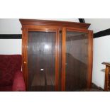 An Edwardian walnut bookcase, the upper section enclosed glazed doors over cupboards, 48" wide x 20"