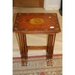 A late 19th century satinwood nest of three tables, tops painted central cherub panel and floral