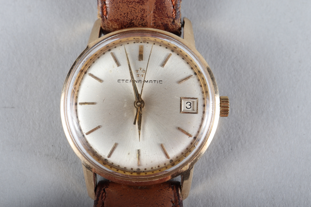 A gentleman's yellow metal cased Eterna Matic wristwatch with silvered dial, baton numerals and date