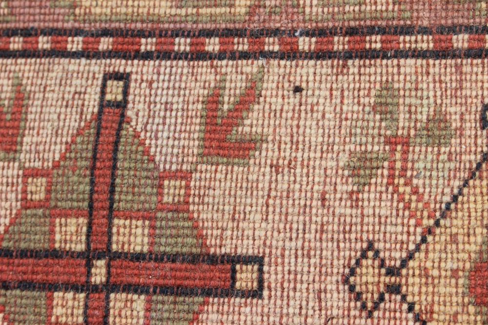 A Caucasian wool pile carpet with central guls and geometric and floral designs, on a terracotta - Image 6 of 6