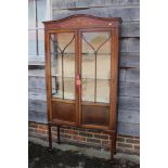 An Edwardian mahogany and painted display cabinet enclosed two lattice glazed doors, on square taper