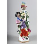 A Continental porcelain scent bottle, in the Chelsea manner, figures round a flowering bush, 4" high