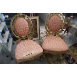 A pair of French giltwood framed salon chairs with oval backs, upholstered in a pink brocade, on