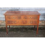 An Edwardian mahogany and satinwood banded chest of two short and one long drawer, on square taper