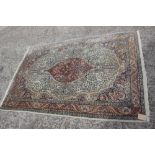 A Kirman rug with all-over flower and tree design and central rust medallion, 72" x 49" approx