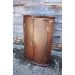 A Georgian mahogany bowfront corner hanging cupboard enclosed two doors, 28" wide x 20" deep x 41"