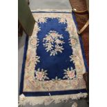 A Chinese contour pile rug with floral design on a blue ground, 64" x 36" approx