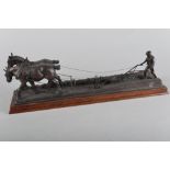 A cold cast bronze sculpture of a farmer ploughing a field with work horses, 18 1/4" wide