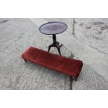 A 19th century mahogany framed long footstool, upholstered in a red velvet, and a circular