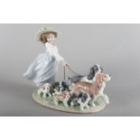 A Lladro porcelain figure of a girl with dogs, "Puppy Parade", 9" high, in box