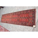 A Mossoul wool pile runner of traditional Persian design in shades of rust, blue, brown and blue,