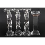 A set of three Kenneth Turner glass candlesticks, on facet cut stems, and another plain square-