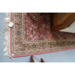 An Axminster rug of Persian design with all-over horse, rider and scroll design on a rust ground,