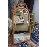 A walnut framed tapering wall mirror with bevelled plate and scrolled decoration, 31 1/2" x 17 1/