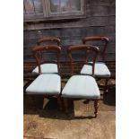 A set of four mid 19th century mahogany balloon back standard dining chairs with stuffed over seats,