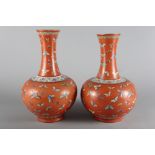 A pair of Chinese baluster vases, decorated butterflies on a terracotta ground, 15 1/2" high