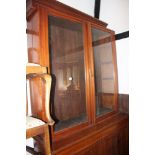 An Edwardian walnut bookcase, the upper section enclosed glazed doors over cupboards, 48" wide x 20"