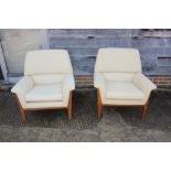 A pair of 1960s Minty oak showframe armchairs, upholstered in a cream linen finish fabric, on