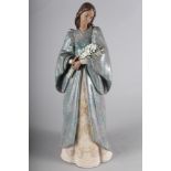 A Lladro porcelain figure of a woman holding a bunch of lilies, "Serenity", 17" high, in box