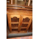 An Indonesian teak cupboard enclosed two spindle decorated doors, 26" wide