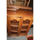An Indonesian teak cupboard enclosed two spindle decorated doors, 26" wide