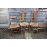 A pair of Arts & Crafts rush seat elbow chairs with triple splat backs