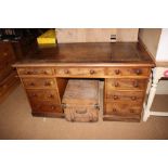 A late Victorian walnut double pedestal desk with brown tooled leather lined top, fitted nine