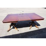 A 19th century mahogany double pedestal dining table with one extra leaf, on turned columns and