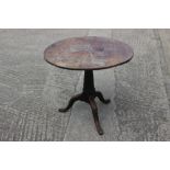 A late 18th century provincial oak circular tilt top occasional table, on cannon barrel turned