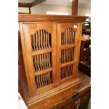 An Indonesian teak cupboard enclosed two spindle decorated doors, 26" wide