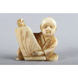 An early 20th century carved ivory netsuke, formed as a seated man with scroll, 1 1/4" high