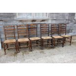 A closely matched set of eight oak rush seat ladderback dining chairs, on turned and stretchered