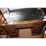 An Edwardian oak double pedestal desk with tooled lined top, fitted nine drawers with brass handles,