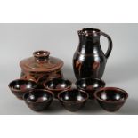 Paul Green: a stoneware jug with splash glaze, 11" high, and six bowls 5 1/2" dia, and a similar