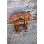 * A nest of three figured walnut shape top occasional tables, on spindle turned and stretchered