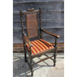 An oak carver chair of Restoration design with caned panel back and drop-in seat, on turned and
