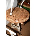 A cast iron and painted circular garden table with pierced decoration and tripod supports, 24" dia