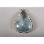 An aquamarine drop-shaped pebble with yellow metal pendant mount