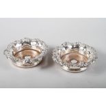 A pair of silver plated wine coasters with grape vine decoration, 7 1/2" dia overall