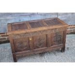 An early 18th century oak carved coffer with triple panel front and "scandal box", on stile