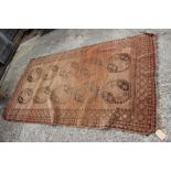 A Bokhara rug with ten central medallions on a faded red ground, 50" x 87" approx