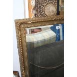 A gilt rectangular wall mirror with carved and pierced decoration and bevelled plate, 23 1/2" x 35